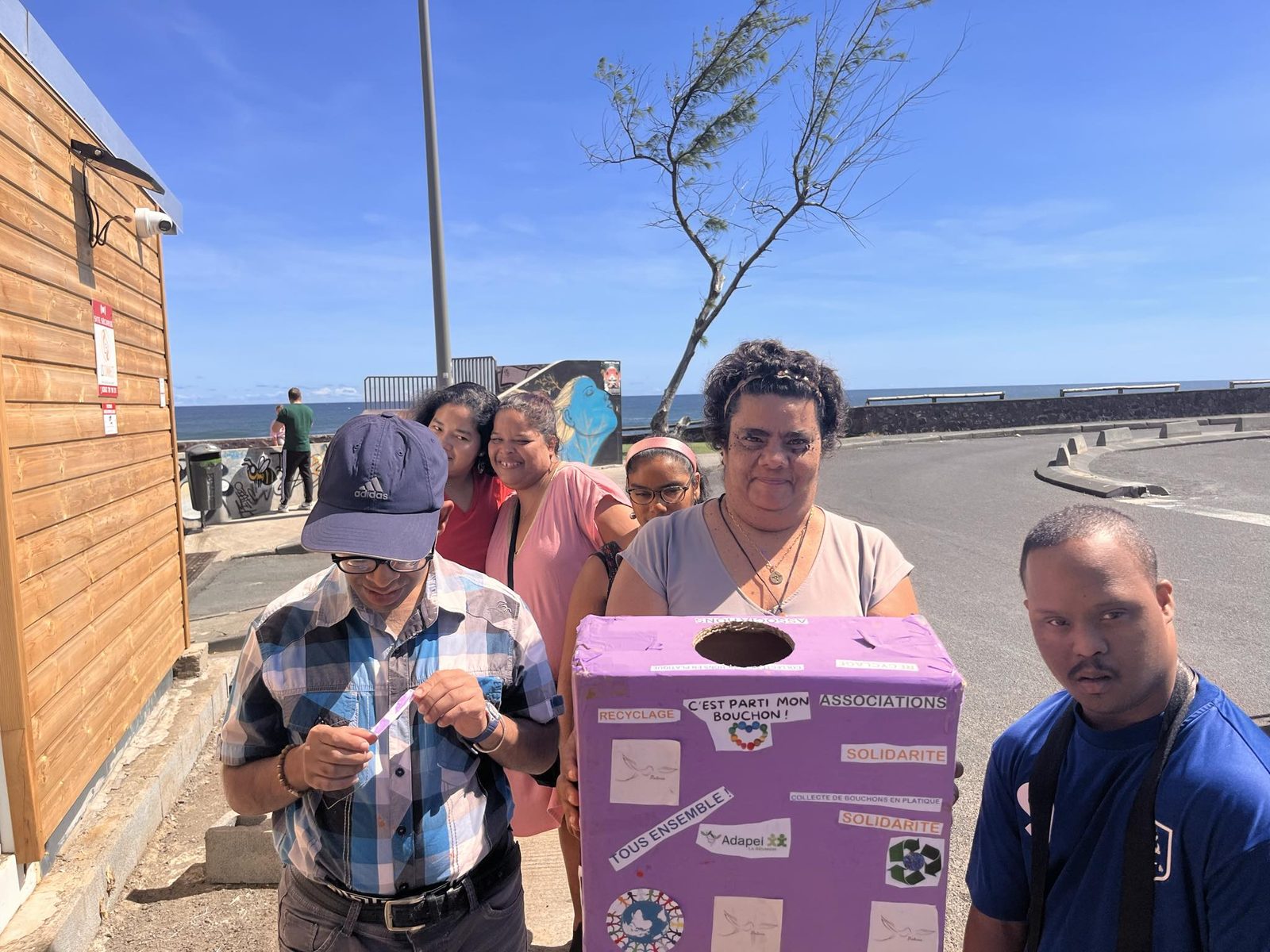 Les résidents avec leur boîte de collecte au bord de mer